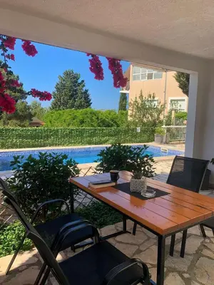 a patio with a wooden table and chairs and a pool at Apartment Tijana in Bar