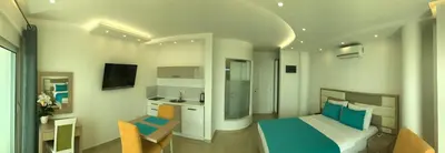 a small room with a bed and a kitchen at Apartments D'Hermes in Ulcinj