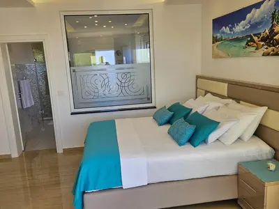 a bedroom with a large bed with blue pillows at Apartments D'Hermes in Ulcinj
