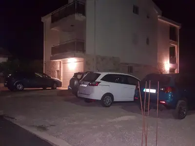 two cars parked in a parking lot in front of a building at Apartment Vila Mirela in Krimovice