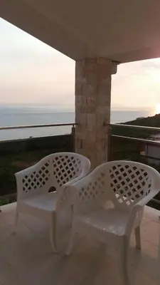 two white chairs on a balcony with a view of the ocean at Apartment Vila Mirela in Krimovice