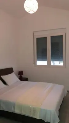 a bedroom with a bed and two windows at Apartment Vila Mirela in Krimovice
