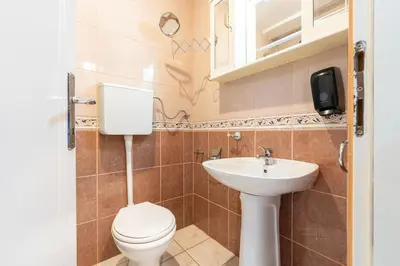 a bathroom with a toilet and a sink at Hotel Bojatours in Podgorica
