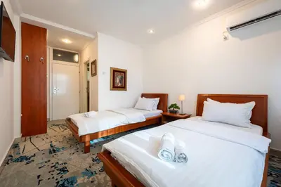 a hotel room with two beds with white sheets at Hotel Bojatours in Podgorica