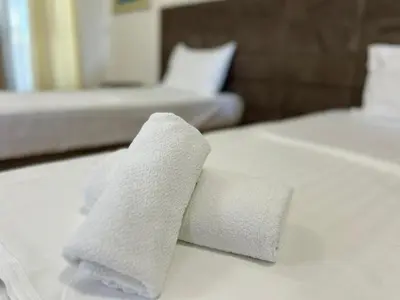 two white towels on top of a bed at Hotel Bojatours in Podgorica