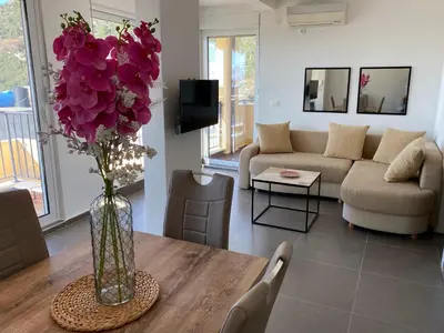 a living room with a vase of purple flowers on a table at Villa Casanego in Sutomore