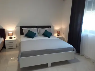a bedroom with a large white bed with two night stands at Apartments Dionis in Kotor