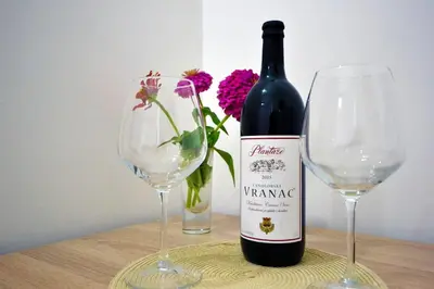 a bottle of wine and two wine glasses on a table at Apartments Dionis in Kotor