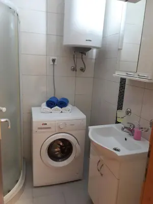 a small bathroom with a washing machine and a sink at Apartments Dionis in Kotor