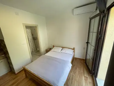 a small bedroom with two beds and a mirror at Apartments Dionis in Kotor