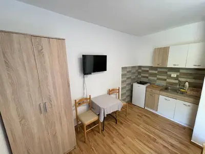 a small kitchen with a small table and a table and chairs at Apartments Dionis in Kotor