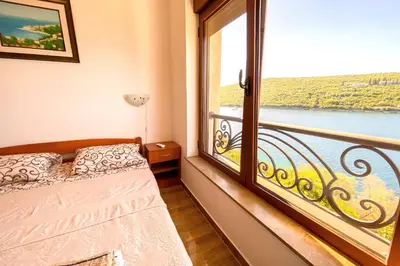 a bedroom with a bed and a large window at ViLena Apartmani in Tivat