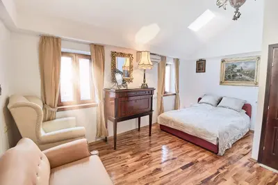 a bedroom with a bed and a table and a chair at Apartments Renaissance Old town in Budva
