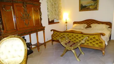 a bedroom with a bed and a chair at Apartments Renaissance Old town in Budva