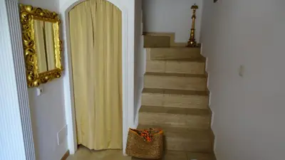 a hallway with a staircase with a mirror and a purse at Apartments Renaissance Old town in Budva