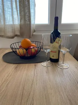 a table with a bowl of oranges and a bottle of wine at Apartments Wild Beauty - Krimovica in Budva