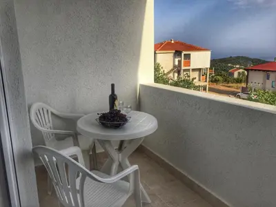 a table with a bottle of wine on a balcony at Apartments Wild Beauty - Krimovica in Budva