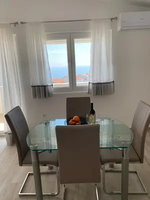 a dining room with a glass table and chairs at Apartments Wild Beauty - Krimovica in Budva