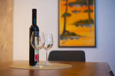 a bottle of wine and two wine glasses on a table at Castelomi in Podgorica