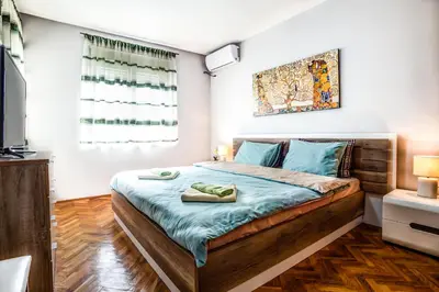 a bedroom with a large bed with blue sheets at Castelomi in Podgorica