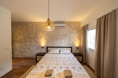 a bedroom with a large bed and a chandelier at Castelomi in Podgorica