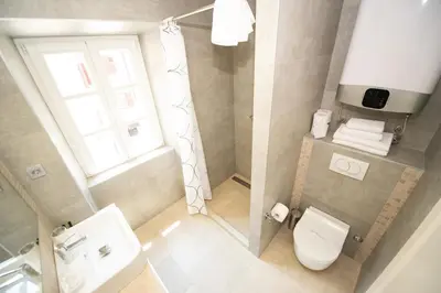 a small bathroom with a toilet and a window at Katareo Apartments in Kotor