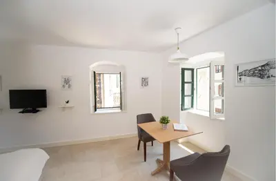 a room with a table and chairs and a tv at Katareo Apartments in Kotor