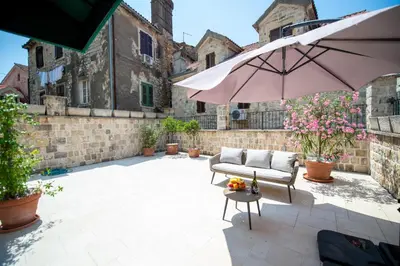 a patio with a couch and an umbrella at Katareo Apartments in Kotor