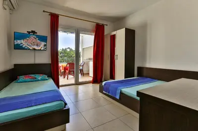 a bedroom with two beds and a view of a patio at Apartments Venezia in Sutomore