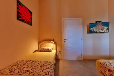 a bedroom with two beds and a white door at Apartments Venezia in Sutomore