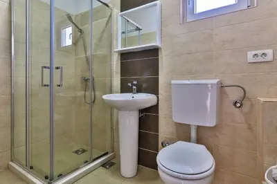 a bathroom with a toilet and a sink and a shower at Apartments Venezia in Sutomore