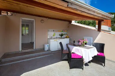 a table and chairs on a patio with a kitchen at Astor apartments in Budva