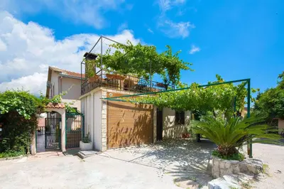 a house with a garage with a fence at Astor apartments in Budva
