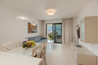 a kitchen and living room with a couch and a table at Apartments Los Olivos in Kotor