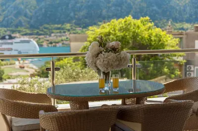 a glass table with a vase of flowers on it at Apartments Los Olivos in Kotor