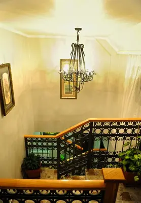 a dining room with a bench and a chandelier at Hotel Evropa in Podgorica