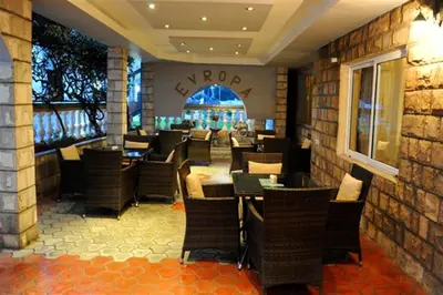 a restaurant with chairs and tables in a room at Hotel Evropa in Podgorica