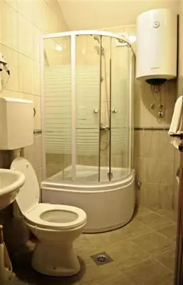 a bathroom with a shower with a toilet and a sink at Hotel Evropa in Podgorica