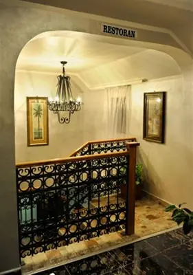 a stairway with a chandelier in a house at Hotel Evropa in Podgorica