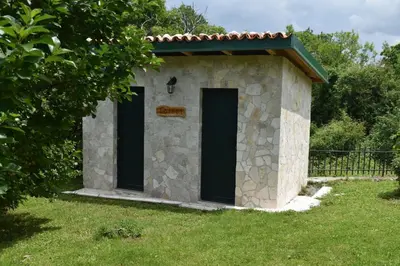 a small stone building with two doors in the grass at Old house Nilovic in Livari