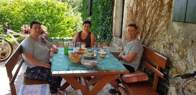 a group of three people sitting around a wooden table at Old house Nilovic in Livari