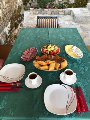 a table with a plate of food and cups of coffee at Old house Nilovic in Livari