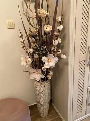 a vase filled with white flowers in a room at Lux Apartments MMS in Budva
