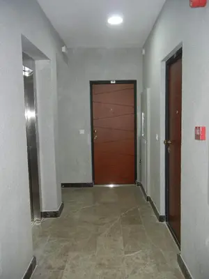 a hallway with a brown door and a tile floor at Apartment More in Budva