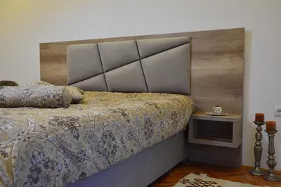 a bedroom with a large bed with a wooden headboard at Guest House Vera in Ulcinj