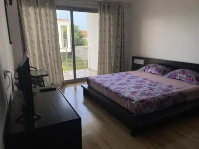 a bedroom with a bed and a television and a window at Leli Apartments in Ulcinj