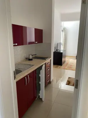 a kitchen with red cabinets and a counter top at Leli Apartments in Ulcinj