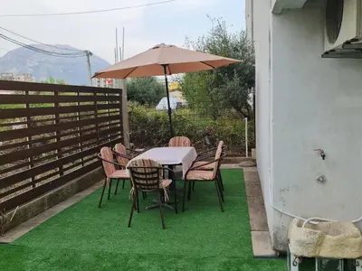 a table and chairs with an umbrella on a patio at Apartmani Sanja in Bar