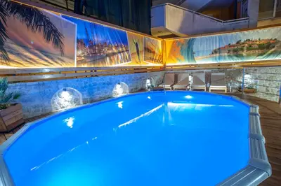 a large blue tub in a room with paintings at Apartments Dzaleta in Sveti Stefan