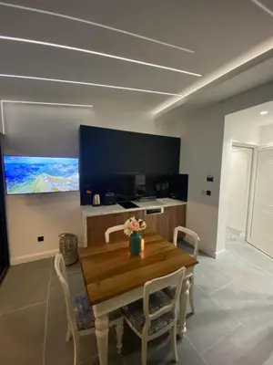 a dining room with a wooden table and chairs at Apartments Dzaleta in Sveti Stefan